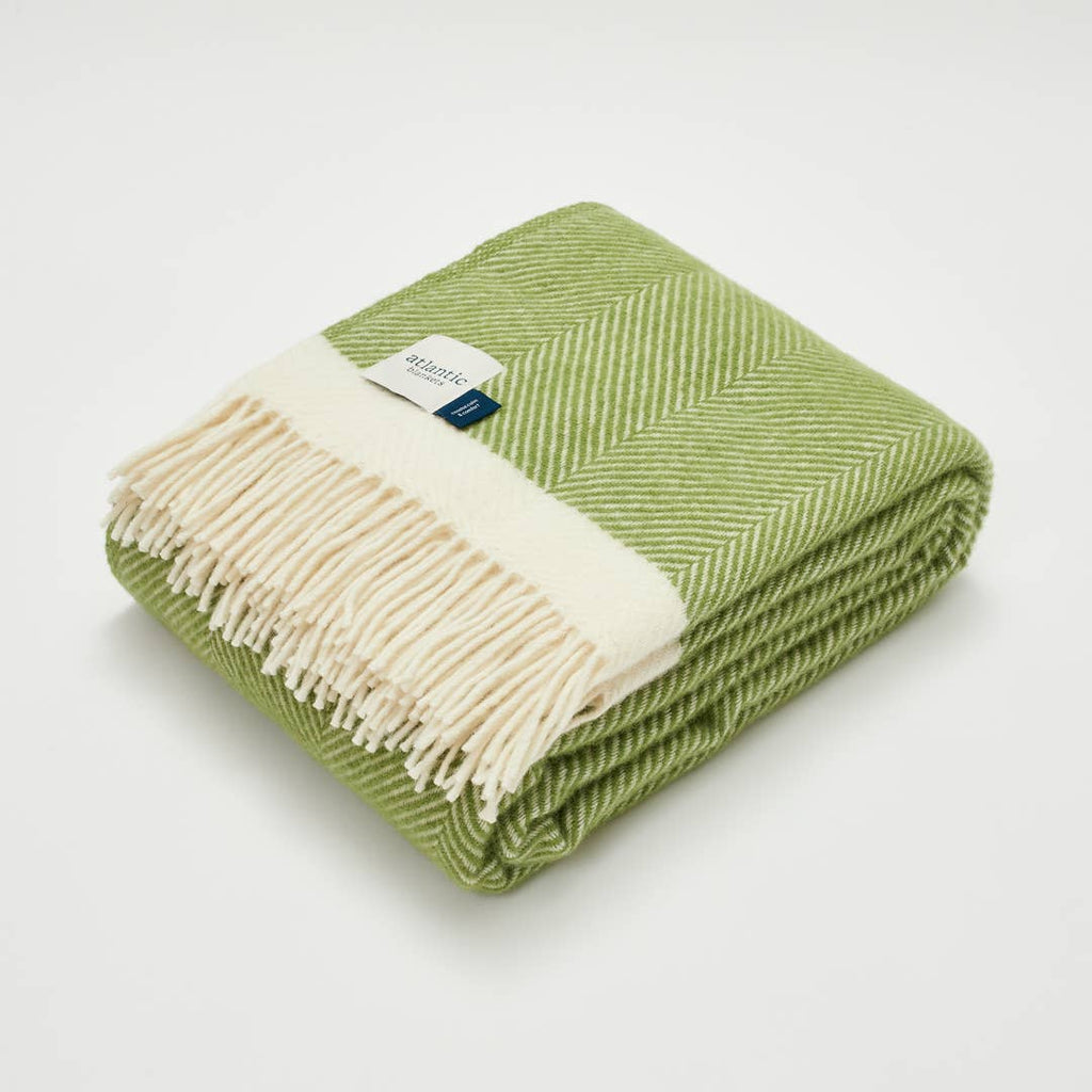 Green herringbone wool blanket folded on sofa natural home decor